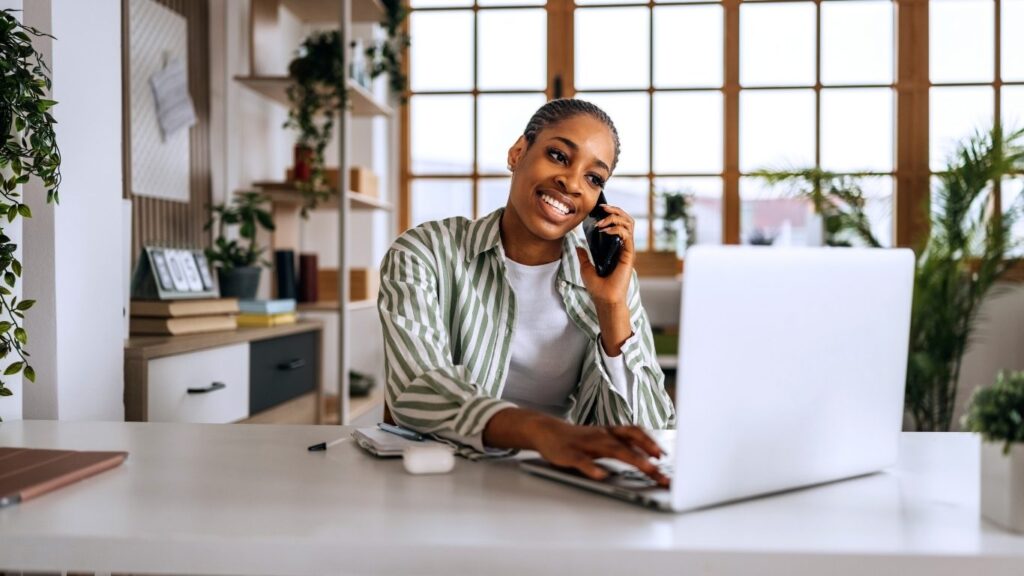 Successful life coach working from home managing a virtual coaching business and client marketing.